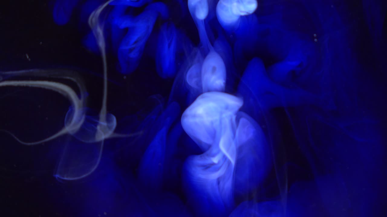 Filmato 4K. Sfondo astratto blu e colorato con cascata di pittura e diffusione di inchiostro