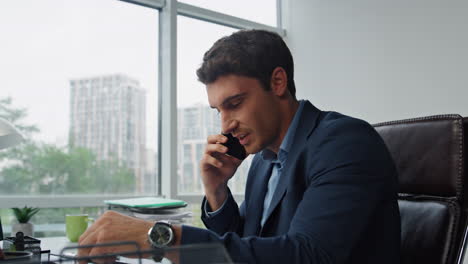 Smiling-entrepreneur-talking-mobile-phone-closeup.-Confident-executive-working