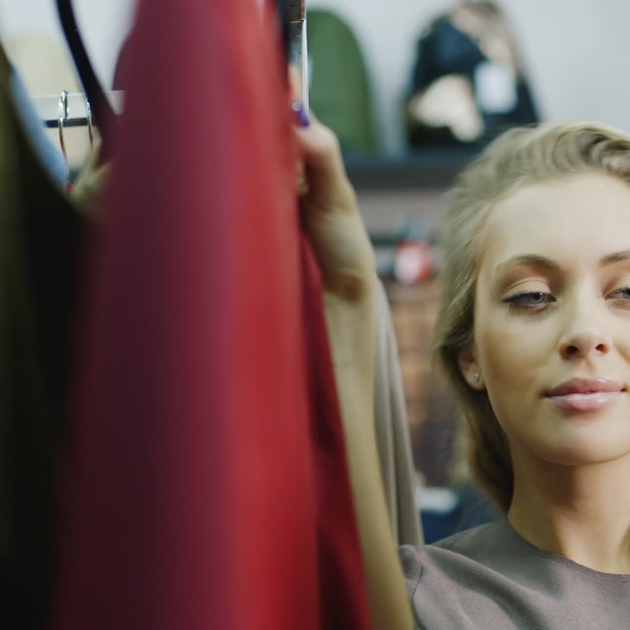 mujer joven elige un vestido en una tienda