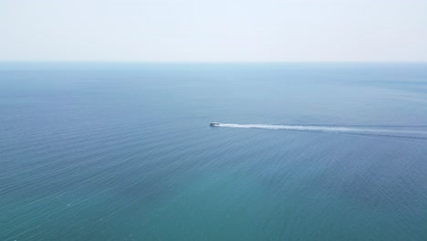 tracking speed boat on open ocean - slow motion drone shot