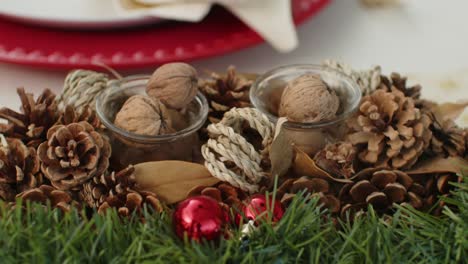 holiday table decor made of pinecones nuts greenery and red baubles