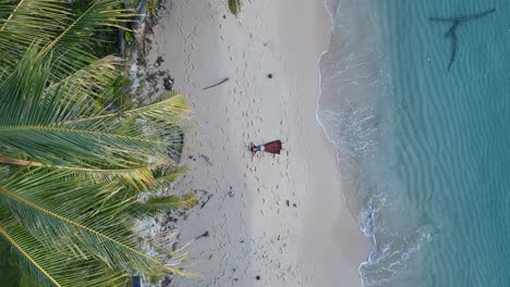 Mädchen,-Das-Allein-Mit-Langem-Kleid-An-Einem-Natürlichen,-Unberührten-Strand-Liegt