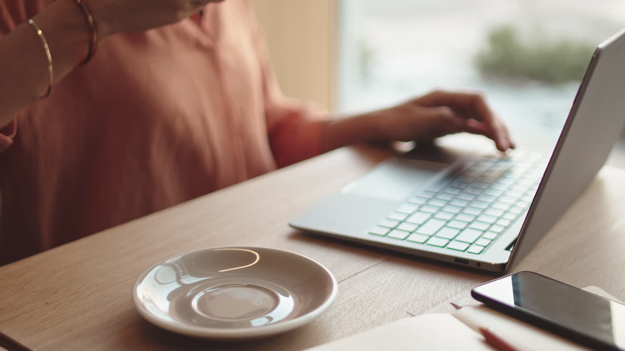 Businesswoman Drinking Coffee and Working in Cafe