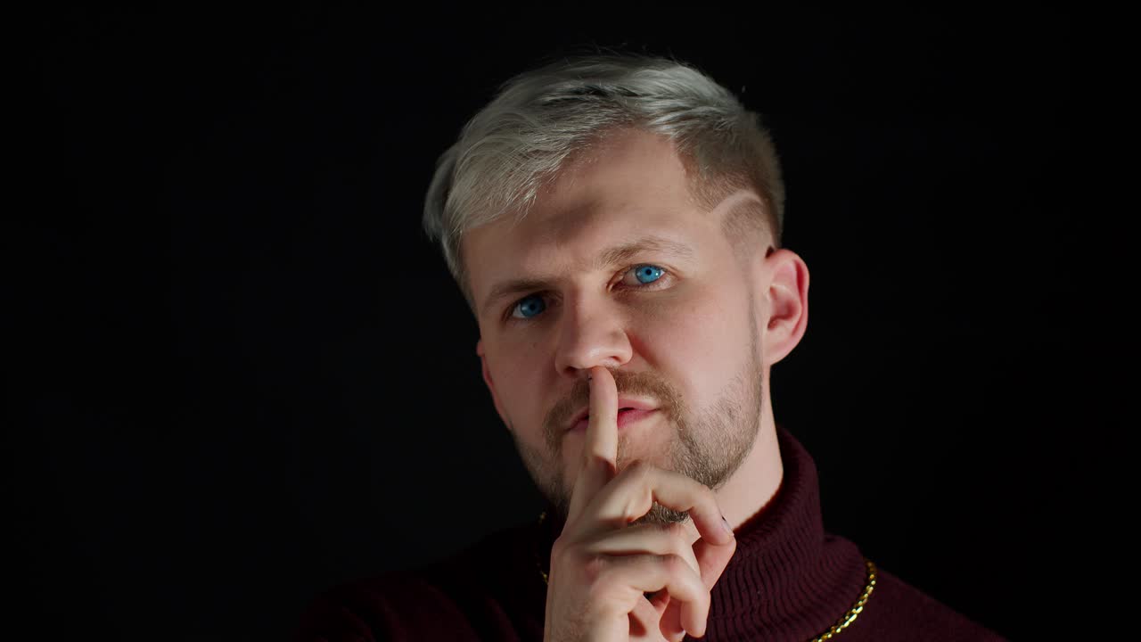 hombre estricto serio pidiendo mantener la calma, mantener el silencio o el secreto con el dedo en los labios gesto shh