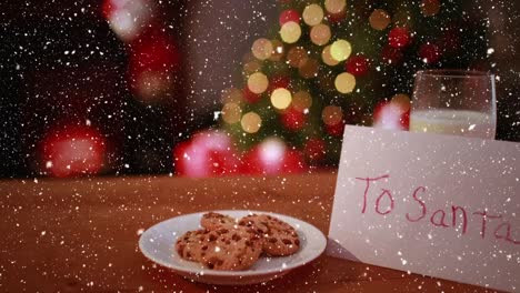 Video-composition-with-falling-snow-over-desk-with-cookies-and-christmas-tree