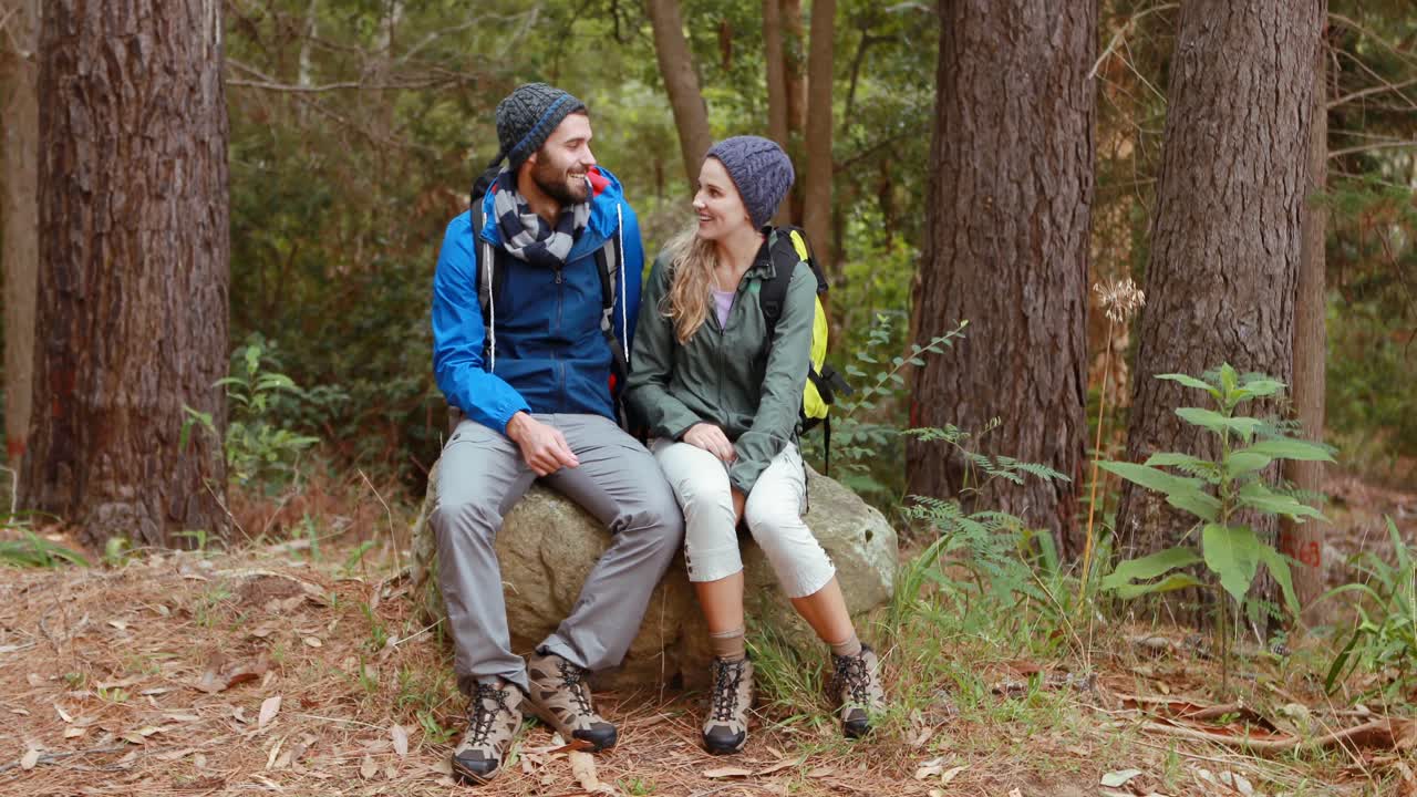 una pareja de excursionistas sentados juntos en una roca