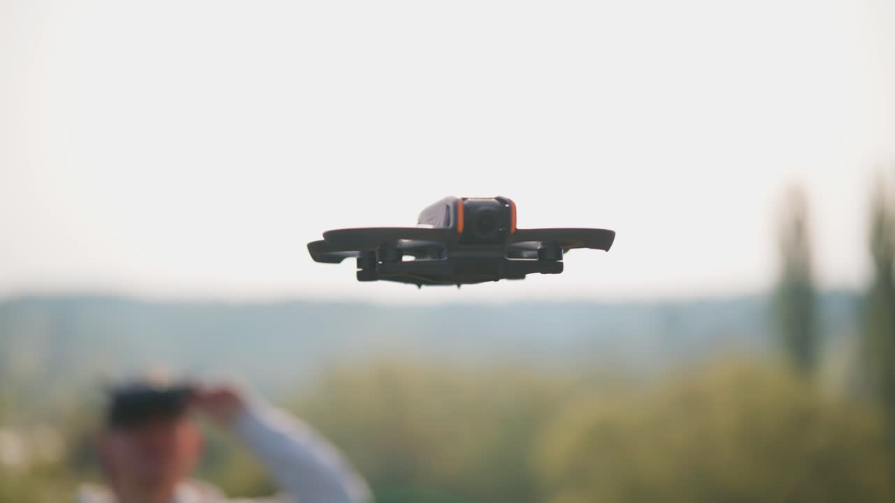 컴트 fpv 드론은 배경에서 조종사 근처에 내려, 공중 감시