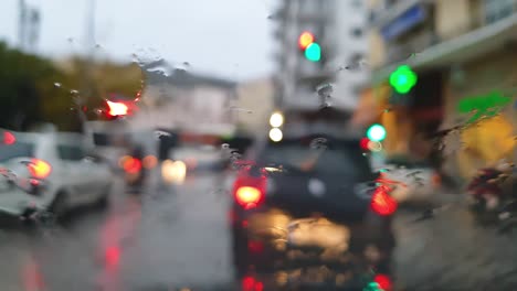 Regentropfen-Auf-Der-Frontscheibe-Eines-Autos-Im-Stadtverkehr