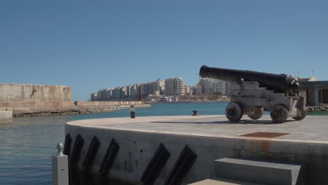 a cannon in the foreground with the the building in tower road as the background