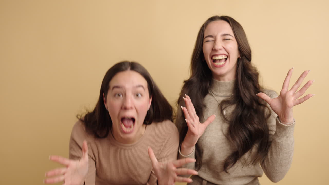 Two women expressing surprise and scream in studio setting