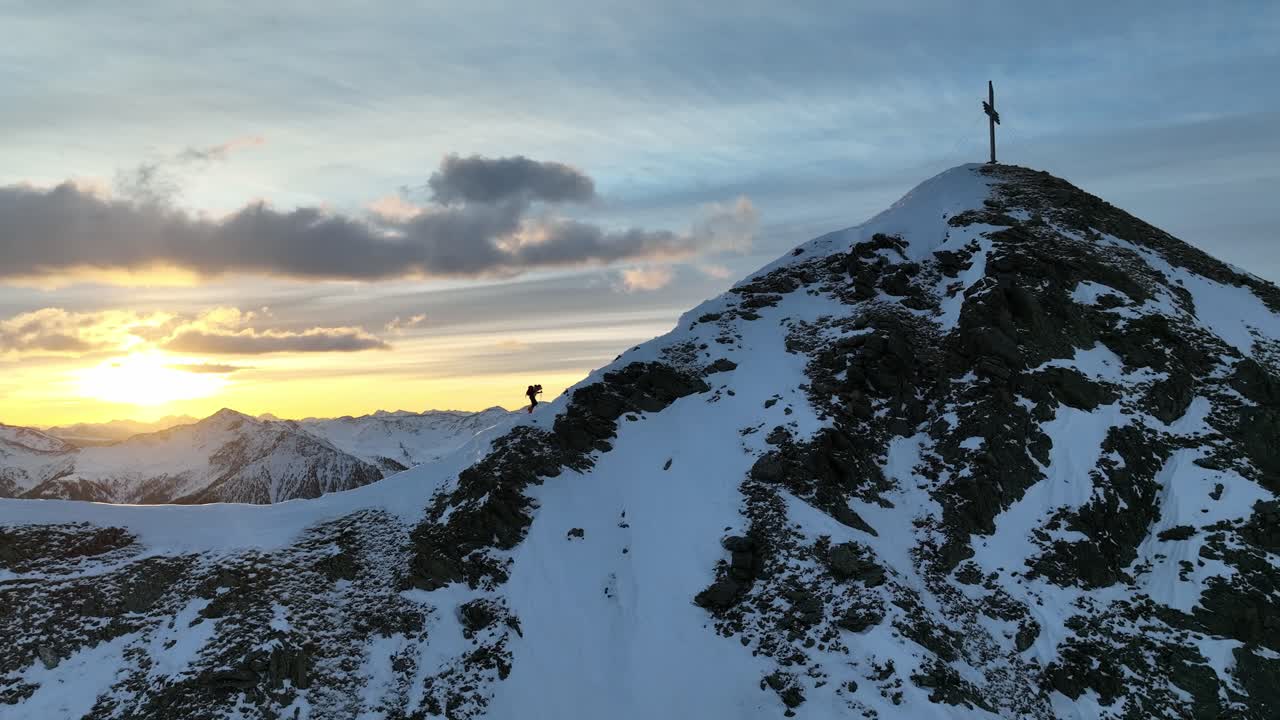 una persona caminando por una cresta cerca de la cumbre en los alpes italianos