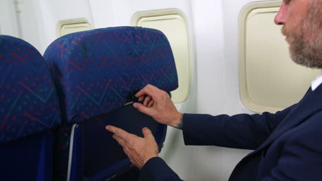 Un-Hombre-Abriendo-Una-Mesa-De-Bandeja-En-Un-Asiento-De-Pasajero-De-Un-Avión