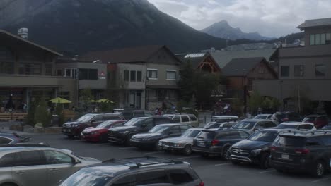full parking lot in downtown banff with mountains in banff