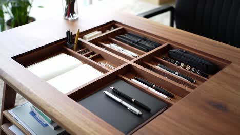 organized office desk with elegant wooden design featuring multiple compartments for pens, notebooks, and stationery supplies in a professional workspace setting