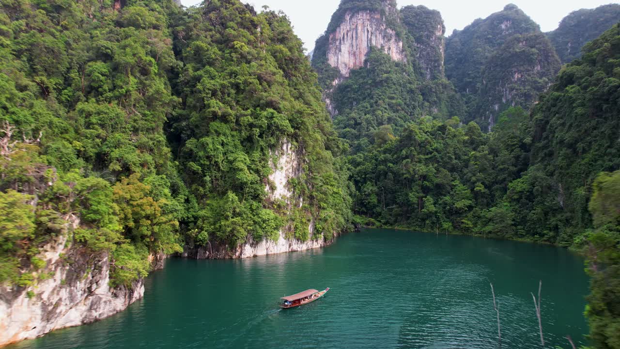 video de dron de 4k volando hacia un barco que navega alrededor del parque nacional de khao sok en tailandia