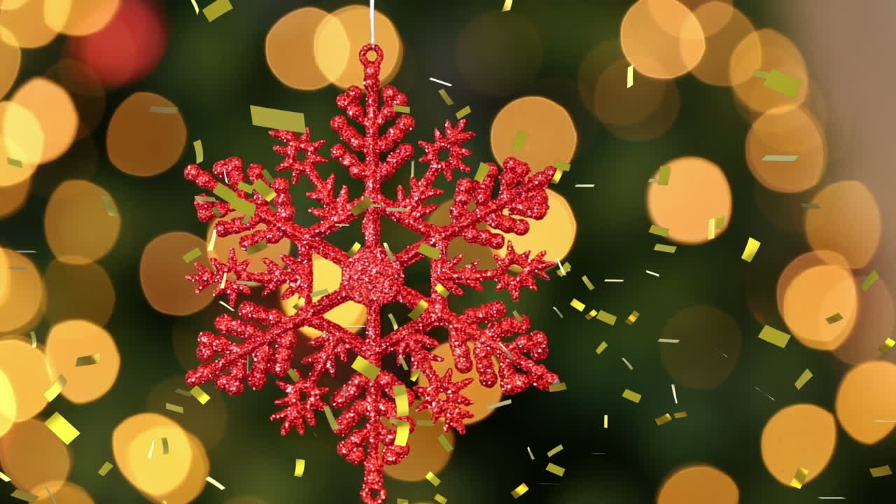 animación de confeti dorado cayendo sobre la decoración del árbol de navidad de copos de nieve rojos, con luces bokeh