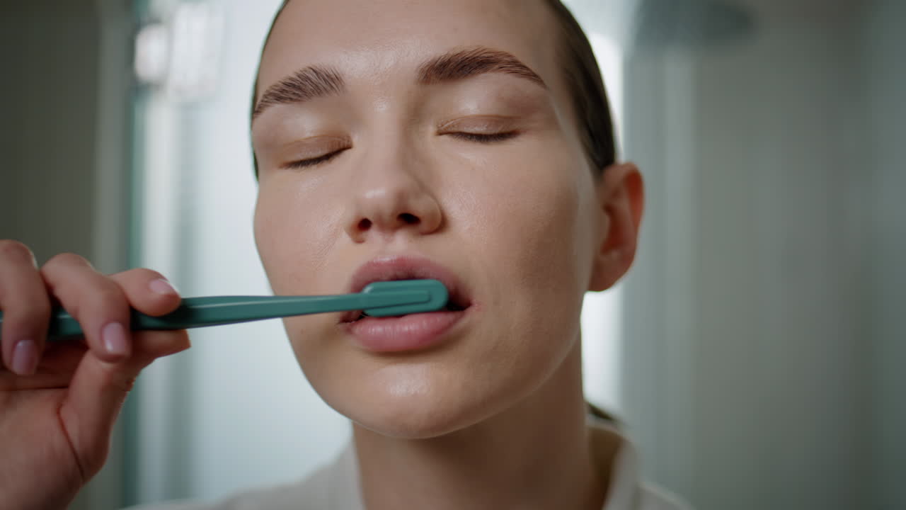 Portrait woman cleaning teeth looking camera at home. girl caring