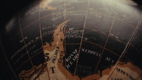 close-up of a vintage world globe focusing on antarctica