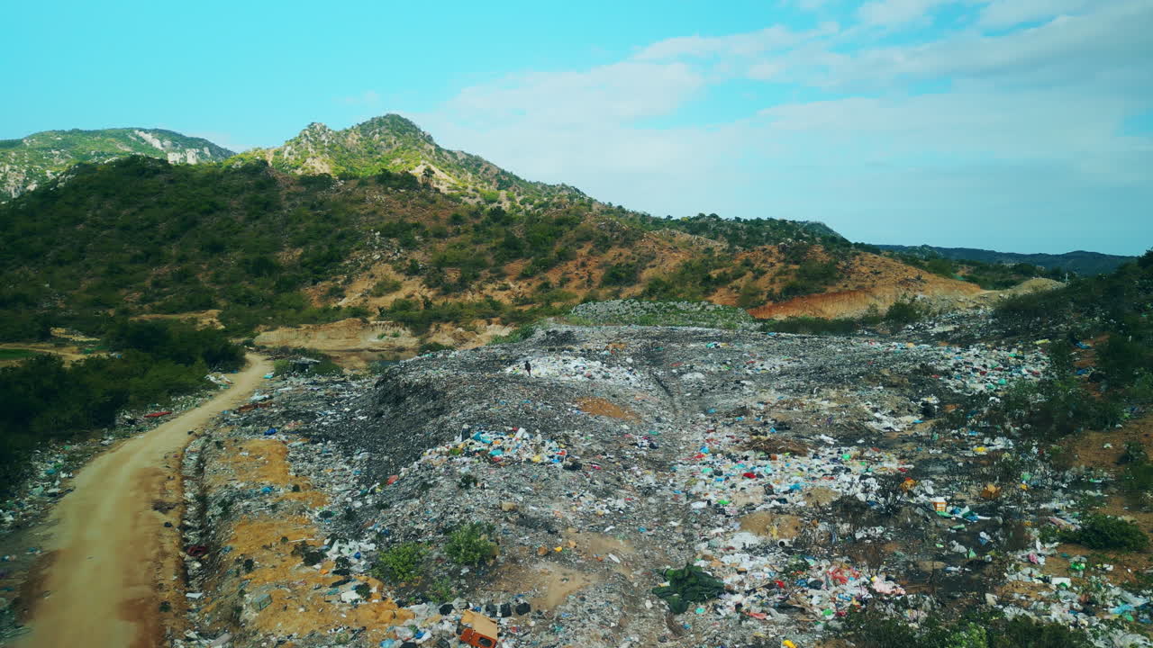 Aerial View of Large Landfill with Mountains in Background