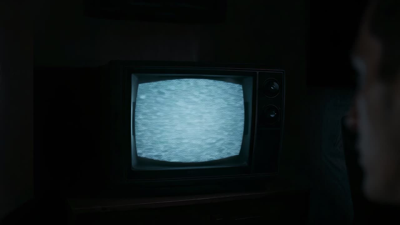 Flickering static drawing man wearing suit jacket glancing while watching TV console in dim room
