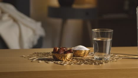 tazón de dátiles con un vaso de agua sobre la mesa en una casa musulmana celebrando el eid 5