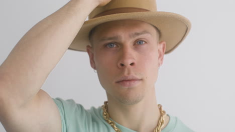 portrait of young man putting a hat on, looks at front and then, moves his head 2