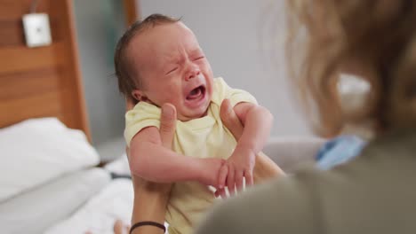 video of newborn baby holding by mum and crying