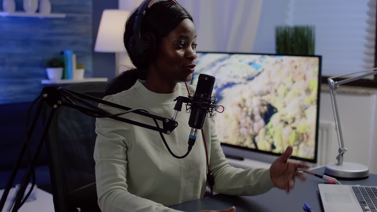 Black vlogger speaking with followers on live podcast using microphone