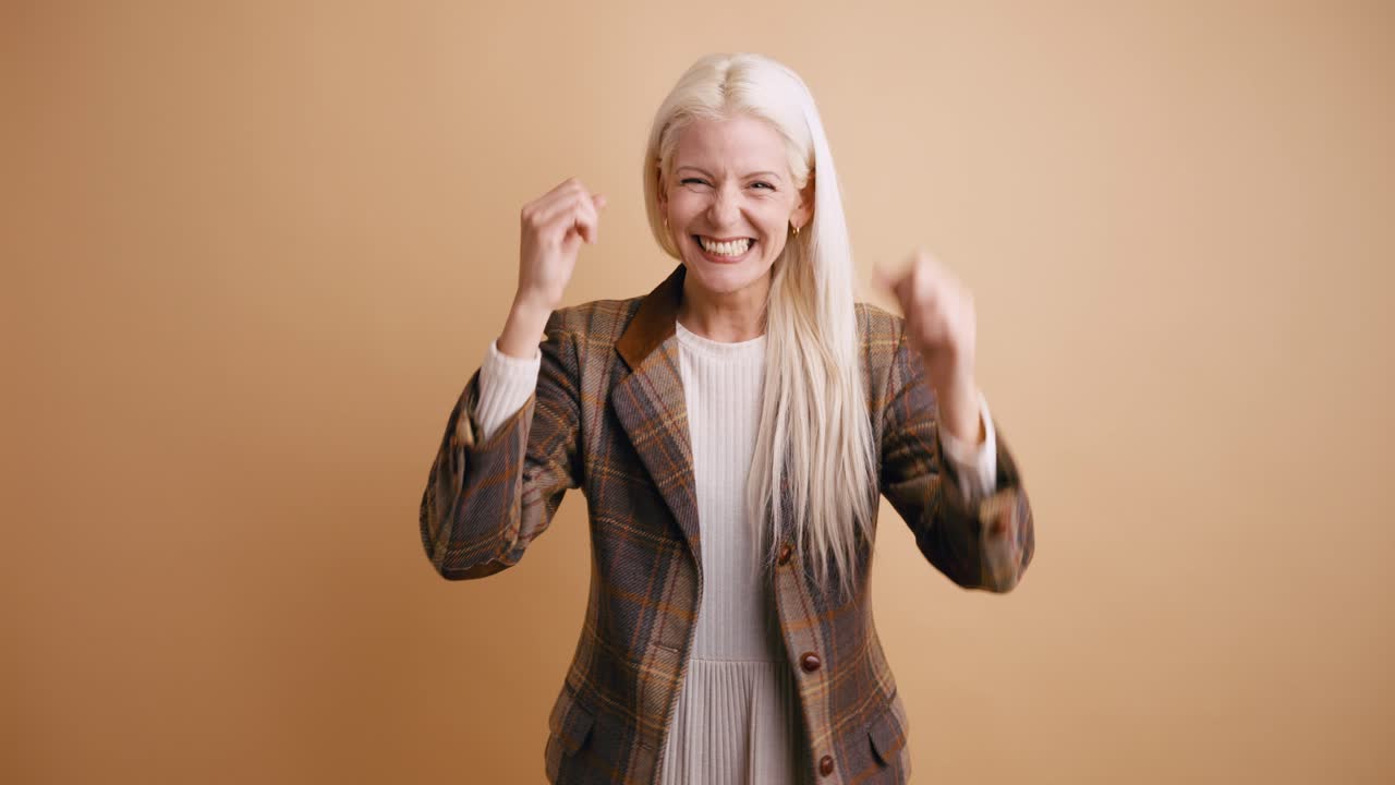 Giovane donna estasiata che celebra il successo con espressione gioiosa