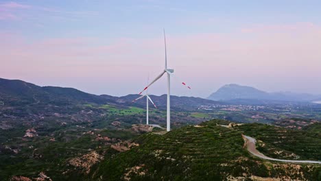 Wind-turbines-with-spinning-blades-against-evening-mountain-skyline-at-Daça-peninsula,-Muğla-province