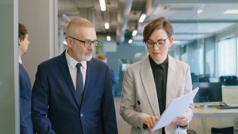 woman talking with colleague while walking in office