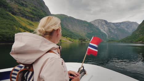 挪威國旗的女性在船的船頭上 fjord cruises 斯堪的納維亞之旅 4k vid