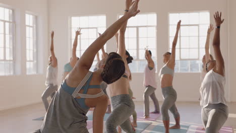 Yoga-Kurslehrer-Unterrichtet-Krieger-Pose-Für-Eine-Schöne-Gruppe-Von-Frauen,-Die-Einen-Gesunden-Lebensstil-Genießen-Und-Bei-Sonnenaufgang-Im-Fitnessstudio-Trainieren