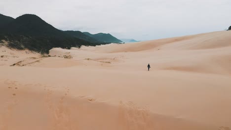 Sandboarder-Zu-Fuß-Auf-Sanddünen-Am-Garopaba-Beach,-Santa-Catarina,-Brasilien