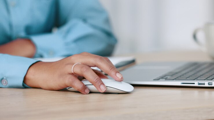 Mani di donna d'affari che cliccano un mouse del computer