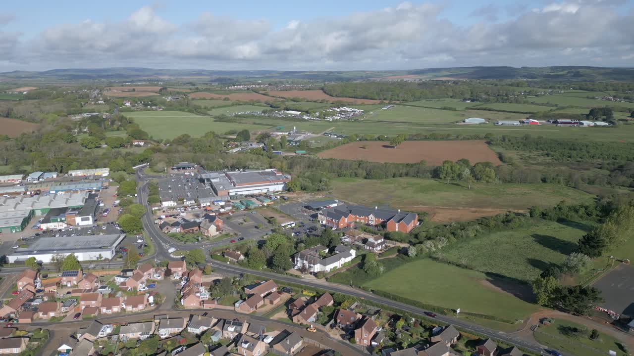 Drone orbit shot of Sandown's rooftops, shops, and fields on Isle of Wight