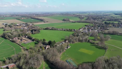 a drone captures the kent village of nonington from a bird's eye view on a sunny day with blue skies and green fields, providing a beautiful and relaxing view