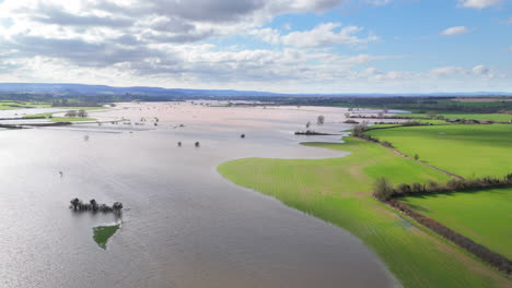 wide aerial trucking view of inundated agricultural land by flood, somerset, uk