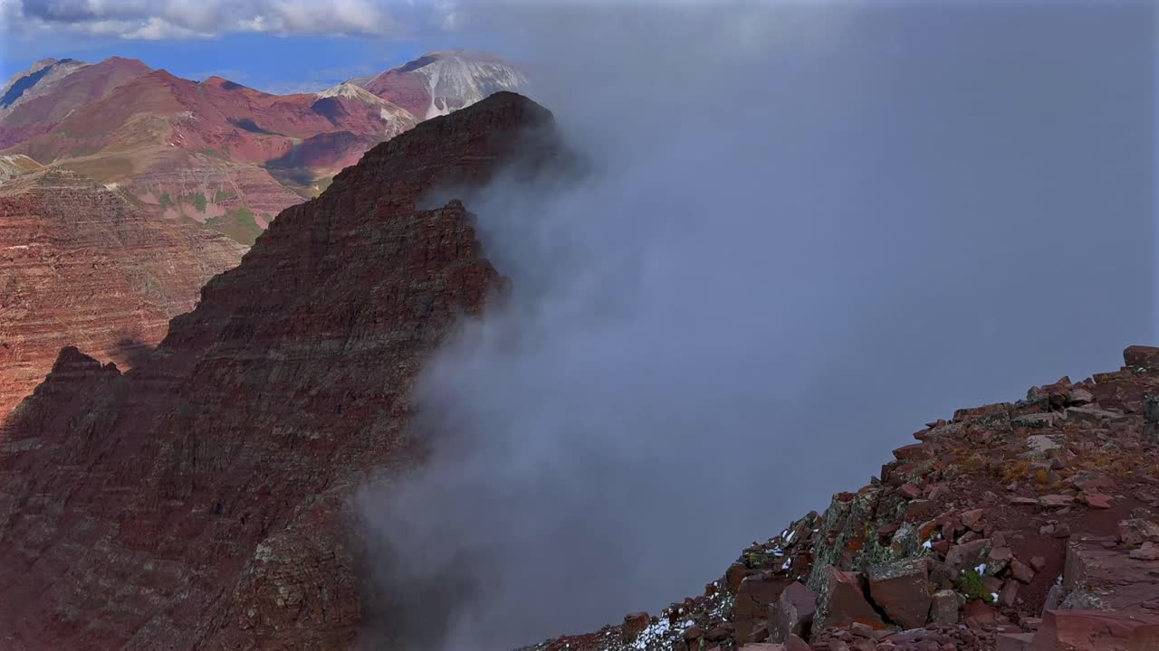 North Maroon Peak dark cloudy thick dense fog Aspen Snowmass Maroon Bells Wilderness valley Colorado summer panoramic view fourteener Elk Range Rocky Mountains rugged terrain static shot
