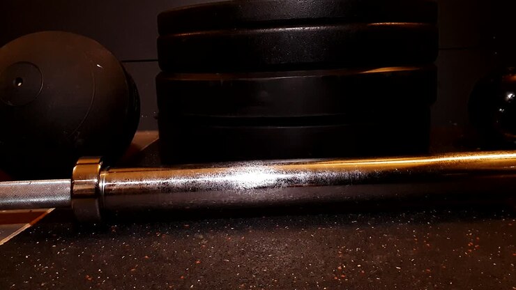 attrezzatura da palestra sdraiata su pavimento in gomma, pesi con bilanciere e kettlebell, movimento fluido del cursore