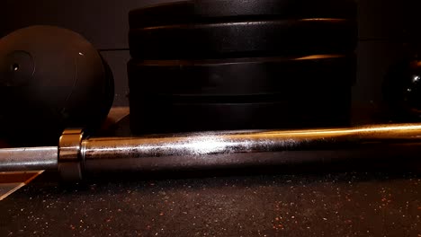 gym equipment lying on rubber floor, barbell ball weights and kettlebell, smooth slider movement