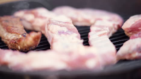 empuje de macro en cámara lenta de carne a la parrilla en parrilla de barbacoa ahumada