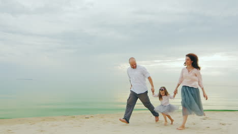 happy family of three people running on the beach 01