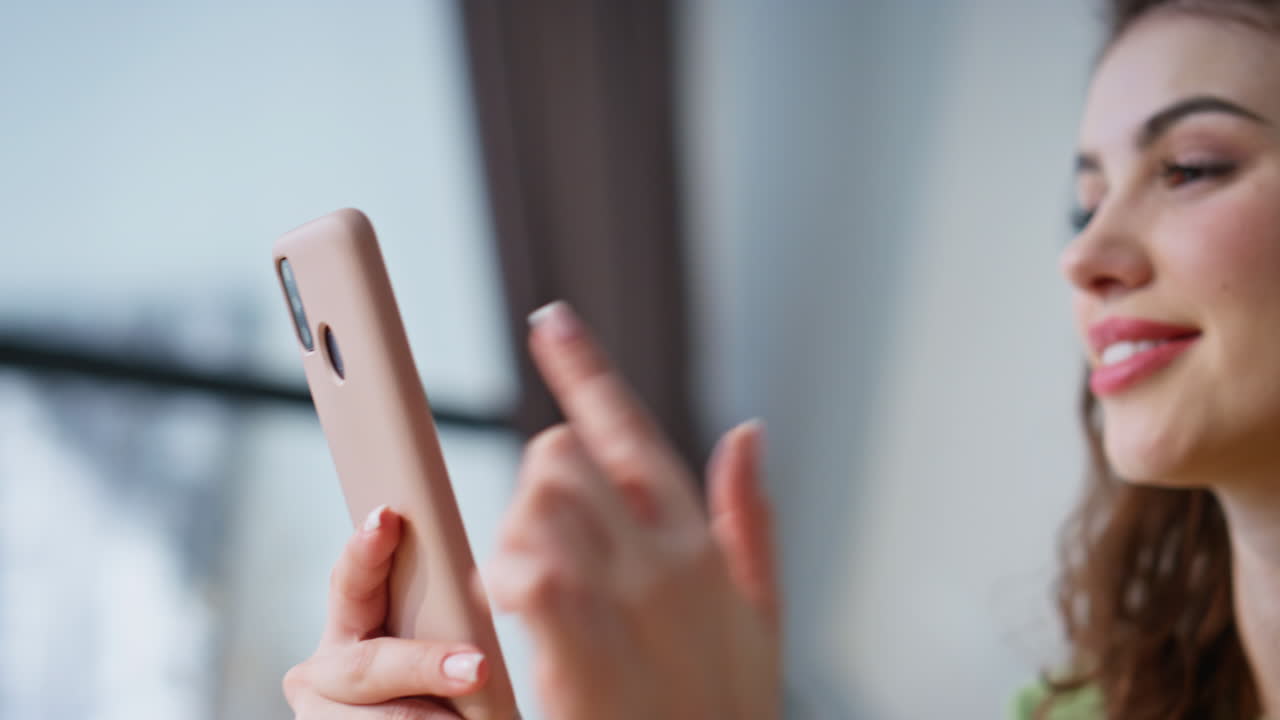 Smiling worker swiping cellphone at workplace closeup. Businesswoman using phone