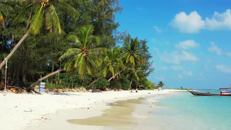 aguas tranquilas y claras de la laguna turquesa que hace espuma en la arena blanca de la playa exótica bajo palmeras inclinadas, cielo nublado brillante en tailandia