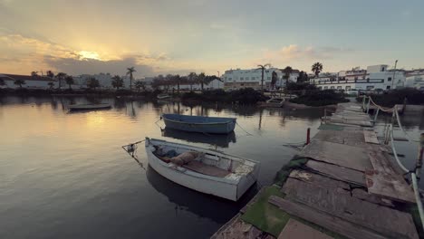 sunset over the town with boats on a calm lake