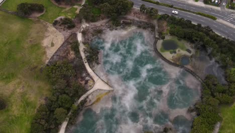 Drone-flyover-hot-steaming-spring-and-board-walkaway-in-Kuirau-Park,-Rotorua,-New-Zealand