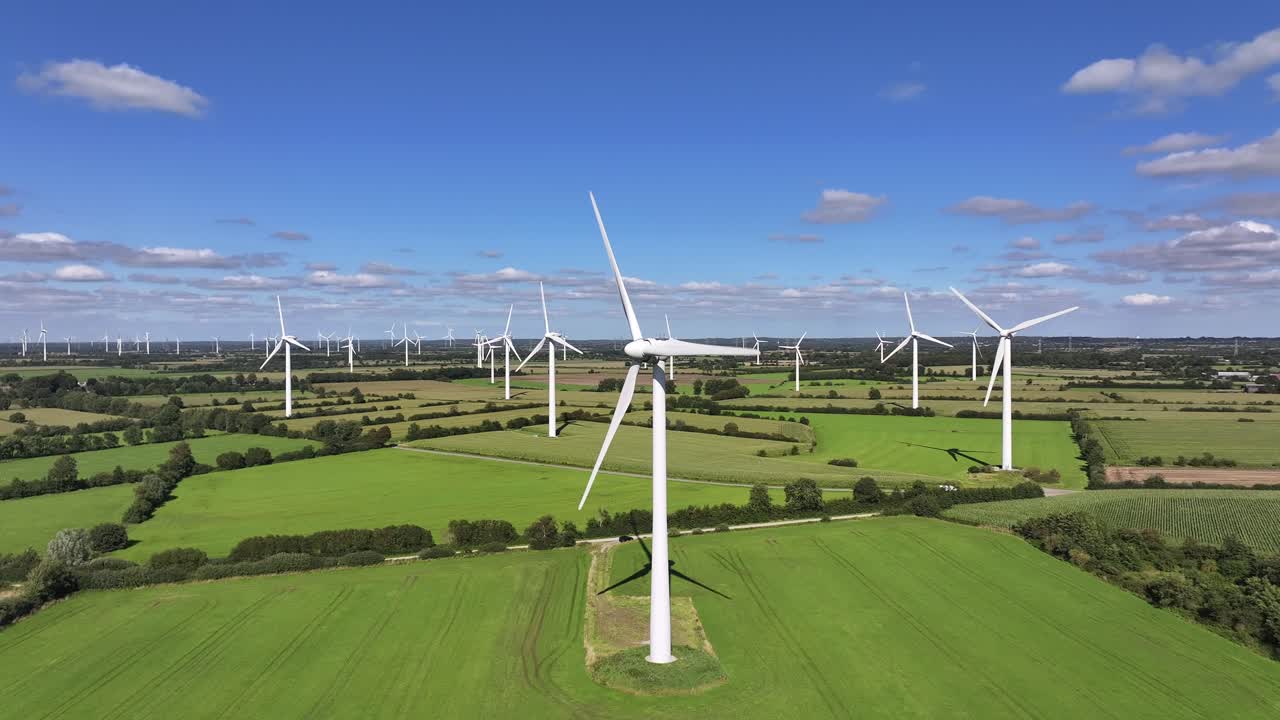 Wind turbines farming wind energy, green fields, blue sky, countryside, sunny, green sustainable power