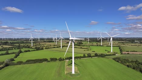 Wind-turbines-farming-wind-energy,-green-fields,-blue-sky,-countryside,-sunny,-green-sustainable-power