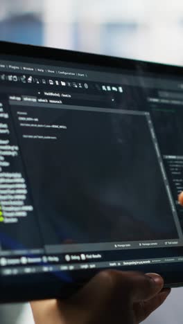vertical video close up of data center software developer checking code on tablet